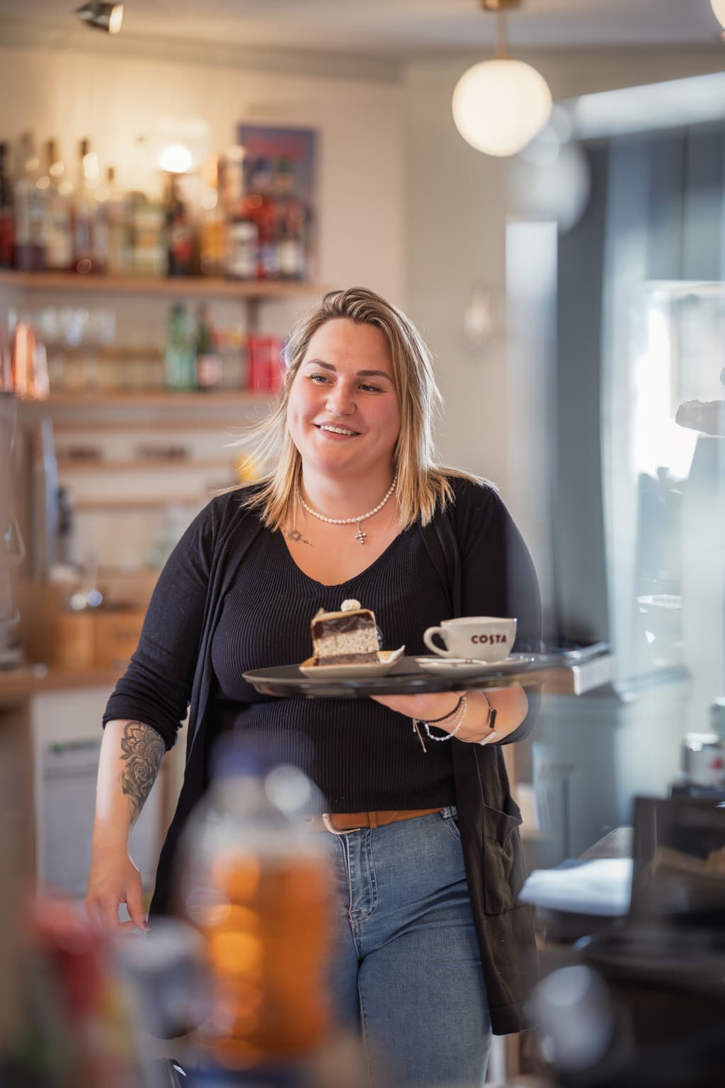 LIVA-Teammitglied serviert Kuchen und Kaffee im Café in St. Gilgen
